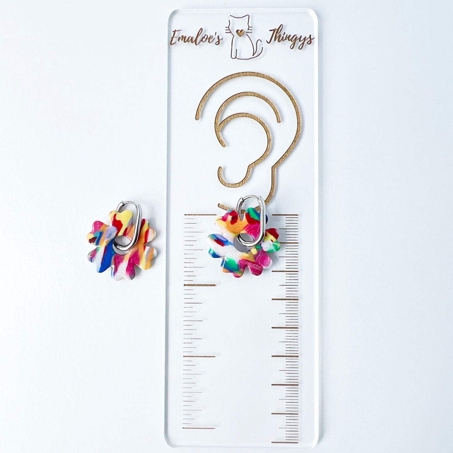 Colorful flower-shaped earrings with 316L surgical stainless steel oval hoops on a white background