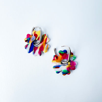 Colorful flower-shaped earrings with 316L surgical stainless steel oval hoops on a white background