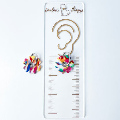 Colorful flower-shaped earrings with 316L surgical stainless steel oval hoops on a white background