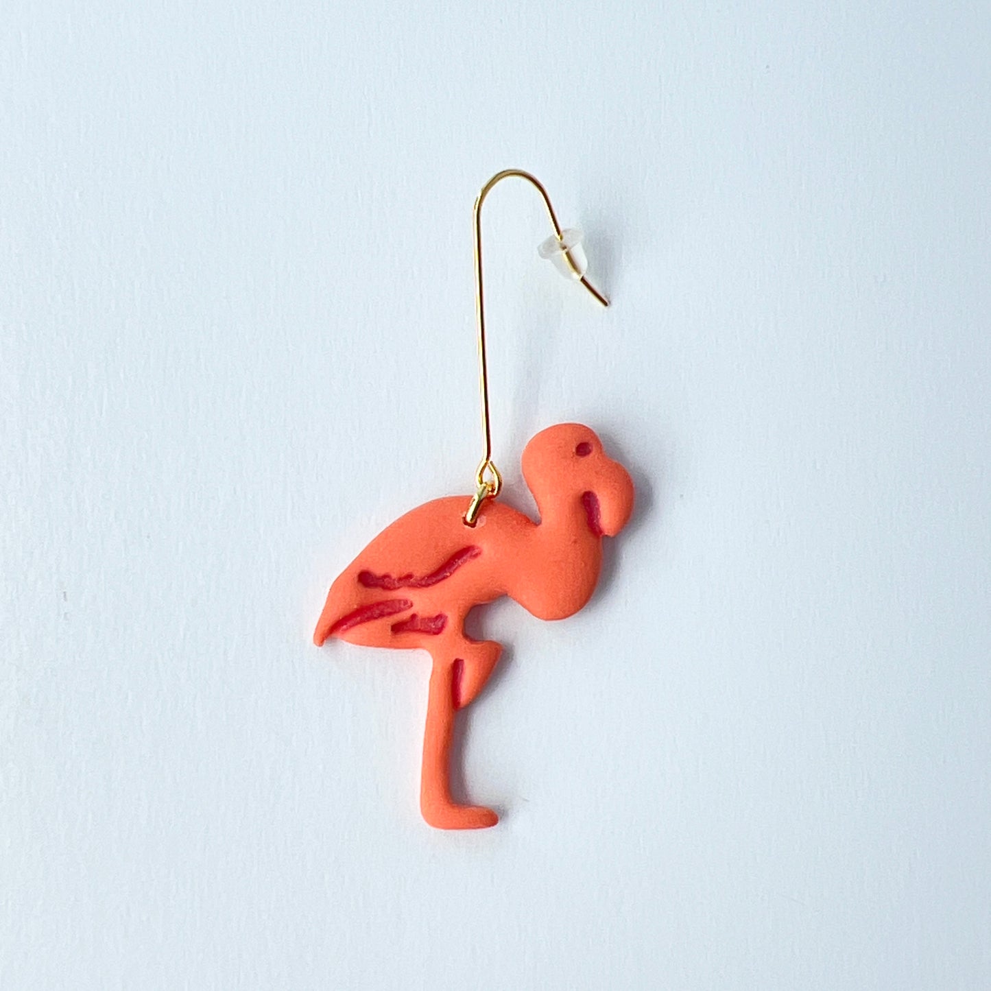 coral Flamingo-shaped earring on a white background